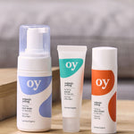 The OY organic, teen and tween skin care gift set with tee tree face wash, purifying serum and cleansing moisturiser which are sat on a wooden table with a grey background
