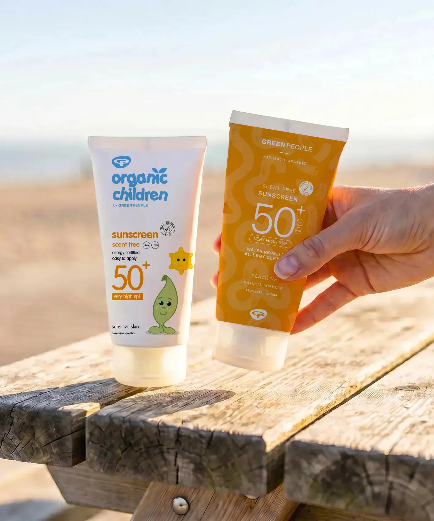 Green People and organic children SPF50 water repellent scent free 150ml sun cream standing on a wooden table