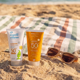 Green People and organic children SPF50 water repellent scent free 150ml sun cream standing on sand