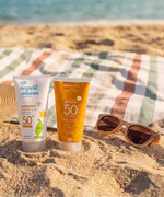 Green People and organic children SPF50 water repellent scent free 150ml sun cream standing on sand