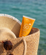 Green People SPF50 water repellent sun cream inside a basket by the sea