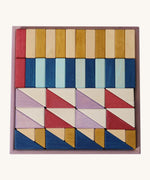 Grimm's wooden rhythm building set in a purple square frame shows handcrafted pieces in different colours
