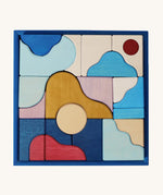 Grimm's wooden wave building set in a blue square frame shows handcrafted pieces in different colours