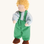 Grimm's Blond Boy Doll - Linde is a Waldorf inspired, soft body, handmade, fabric toy doll with blonde hair, a light blue top, green dungarees and brown shoes, on a cream, background