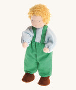Grimm's Blond Boy Doll - Linde is a Waldorf inspired, soft body, handmade, fabric toy doll with blonde hair, a light blue top, green dungarees and brown shoes, on a cream, background