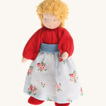 Grimm's Blonde Woman Doll, is a soft body, Waldorf inspired, handmade, fabric toy with blonde hair, a red top, a floral pattern skirt and red shoes. The image is on a cream background