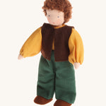 Grimm's Waldorf Brown Haired Man Doll - Erle pictured on a cream background. Erle is a handmade, fabric doll and has light brown hair, green trousers, a yellow top and a brown sleeveless jacket.