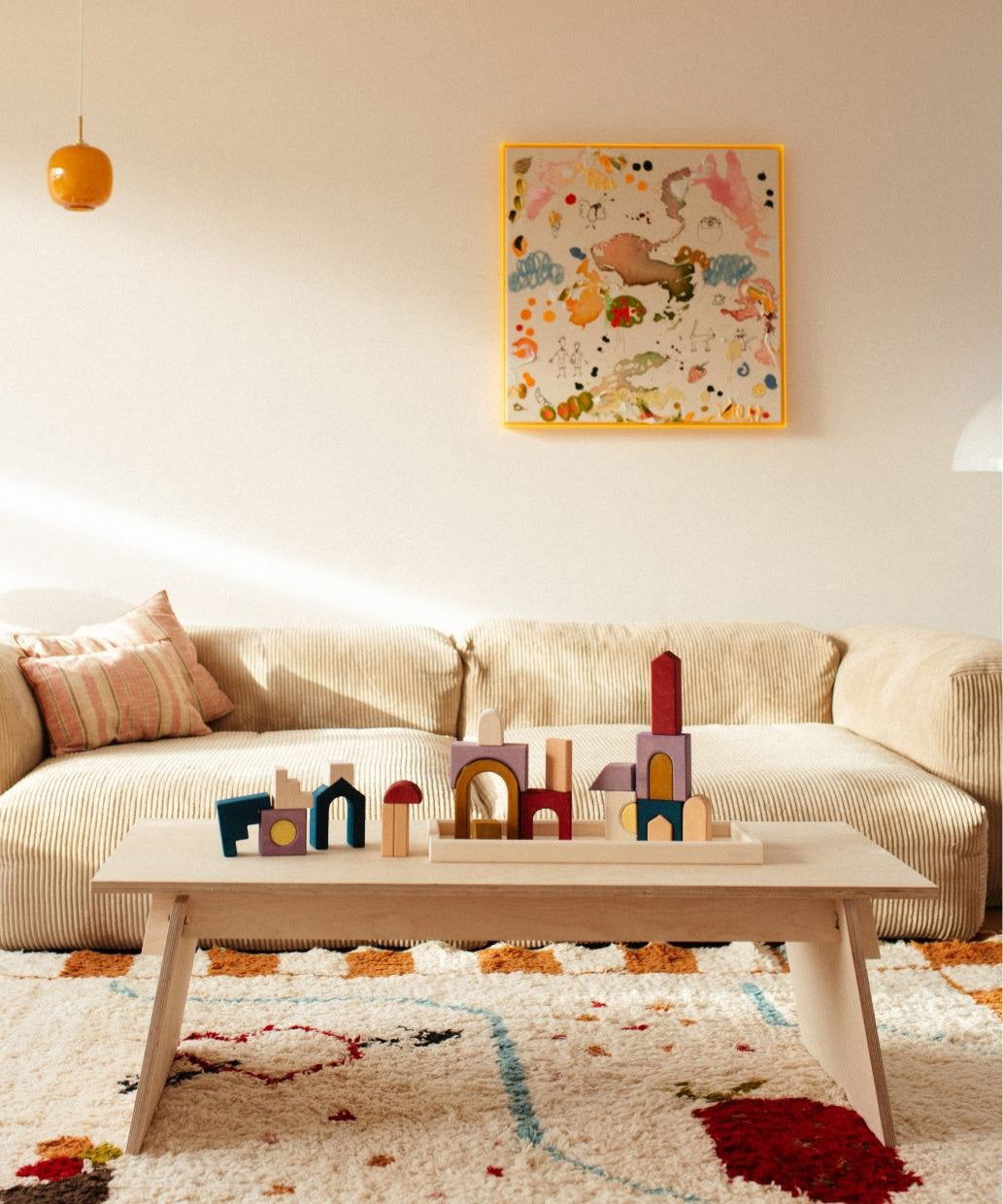 Grimm's wooden panorama building set in a living room setting. Shows pieces loose and stacked on top of eachother 