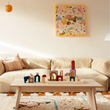 Grimm's wooden panorama building set in a living room setting. Shows pieces loose and stacked on top of eachother 