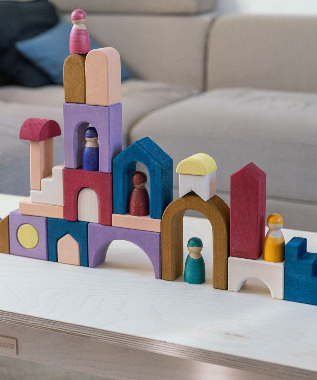 Grimm's wooden panorama building set on a wooden table. Shows different pieces stacked on top of each other 