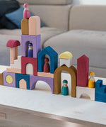 Grimm's wooden panorama building set on a wooden table. Shows different pieces stacked on top of each other 