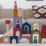 Grimm's wooden panorama building set on a wooden table in a living room setting. Shows pieces stacked on top of eachother 