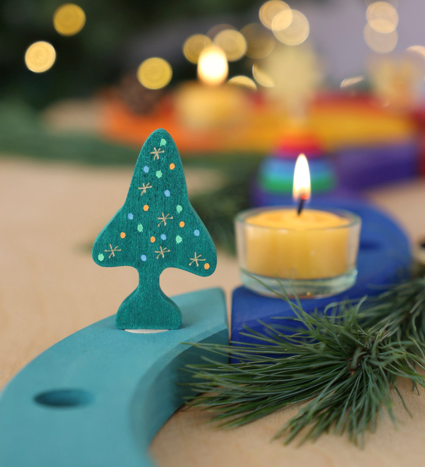 A Grimm's Christmas Tree Celebration Ring Decoration figure available at Babipur inserted into a light blue celebration piece in a festive inspired display. 
