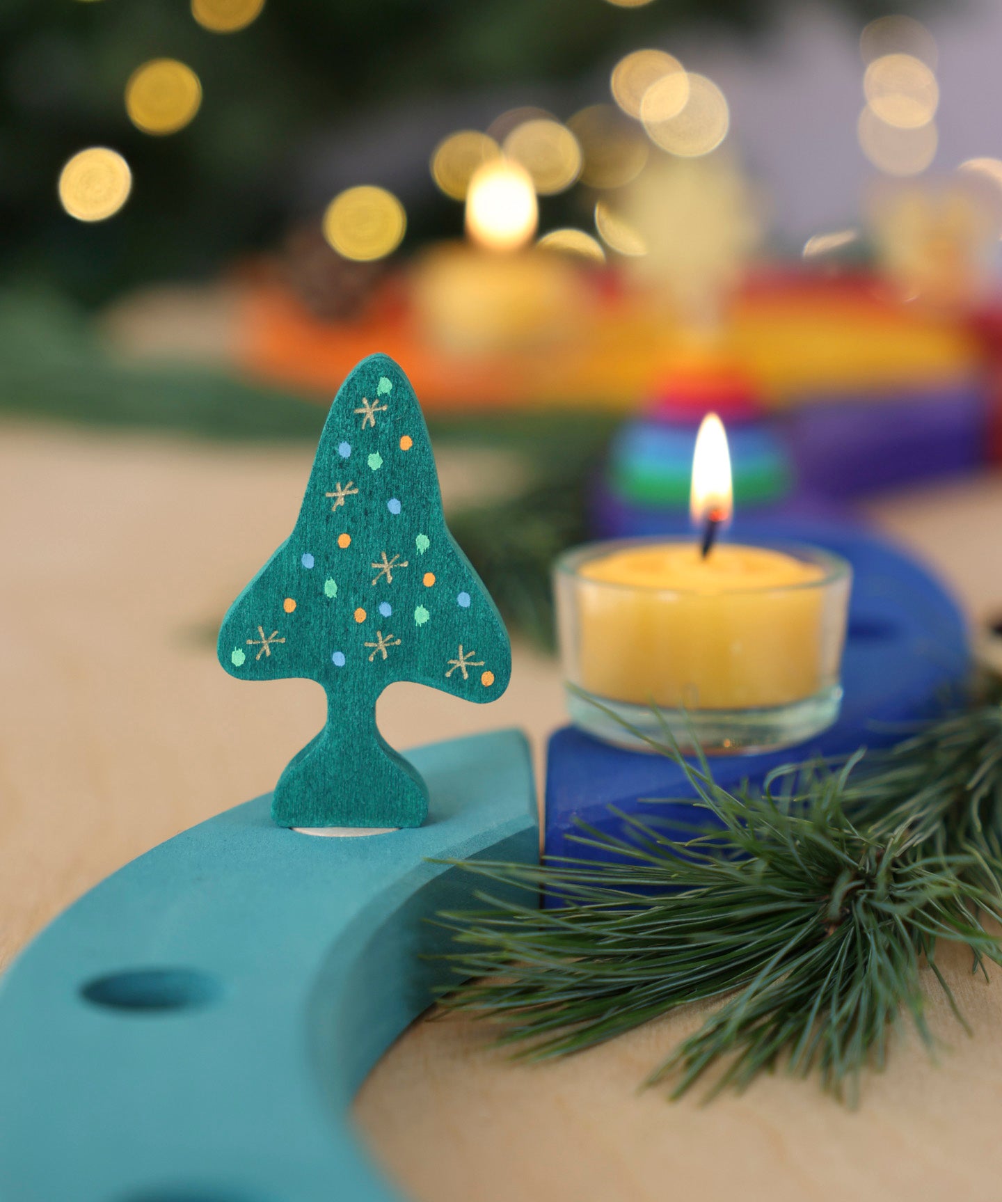 A Grimm's Christmas Tree Celebration Ring Decoration figure available at Babipur inserted into a light blue celebration piece in a festive inspired display. 