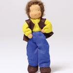 Grimm's Brown Haired Man Doll - Erle standing up with its hands on its hips and one leg forward, showing how little ones can move the arms and legs with ease