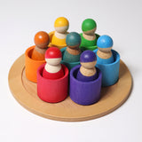 The Grimm's Wooden Friends Peg Dolls sat in the Wooden Grimm's bowls on a cream background