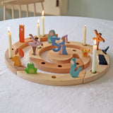 Grimm's natural spiral celebration ring with colorful figures and candles on a white surface