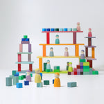 The Grimm's 12 Pastel Friends stood on various levels of a built Grimm's wooden block building 