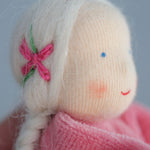 A closer look at the hair on the Grimm's Pink Lavender Girl showing pink embroidered bows with green vines