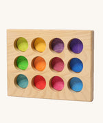 Grimms handcrafted wooden sorting board with 12 round slots in rainbow colours, made for sorting games