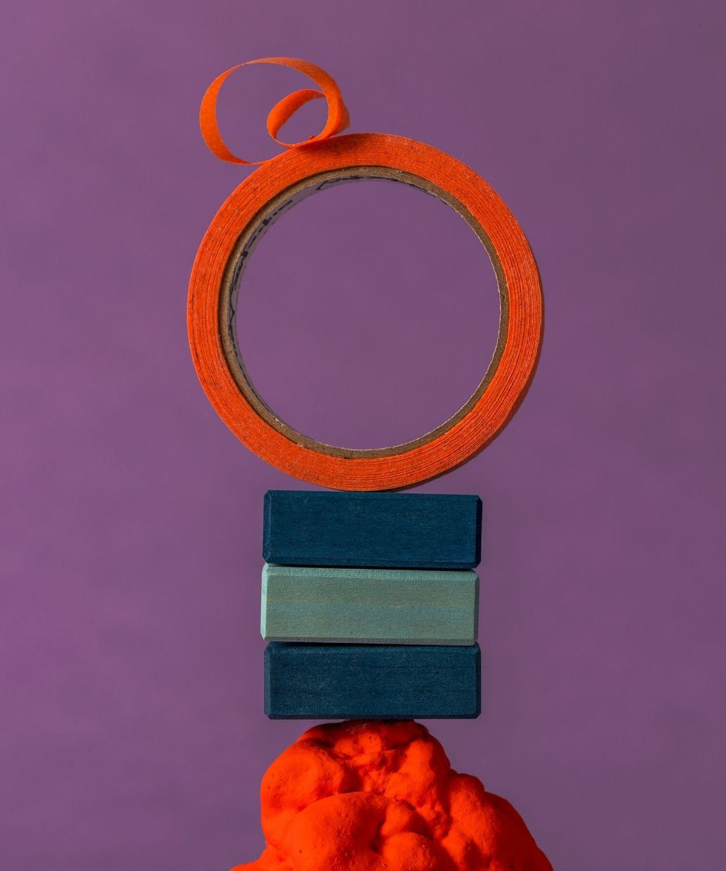 Fancy stack using 3 blue handcrafted Grimms wooden pieces from the rhythm set with orange tape on top