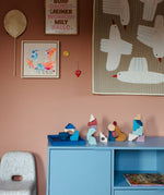 Loose pieces from the Grimms wave hand crafted building set on a blue cupboard in a bedroom setting