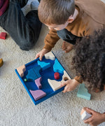 Children playing a game made from the hand crafted Grimm's wooden pieces from the wave set.