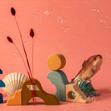 Ocean display using handcrafted Grimms wooden pieces from the wave set against a pink background. 
