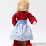 Grimm's Blonde Woman Doll is stood in front of a wooden block of wood, showing how the doll can balance on its feet