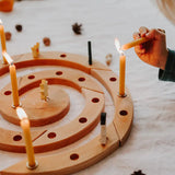 Grimm's natural spiral celebration ring with candles being lit on a light background
