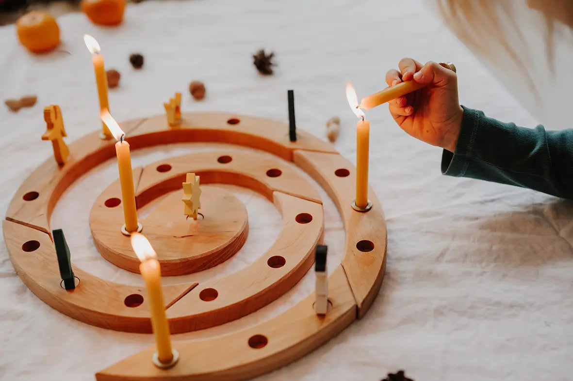Grimm's natural spiral celebration ring with candles being lit on a light background