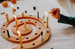 Grimm's natural spiral celebration ring with candles being lit on a light background