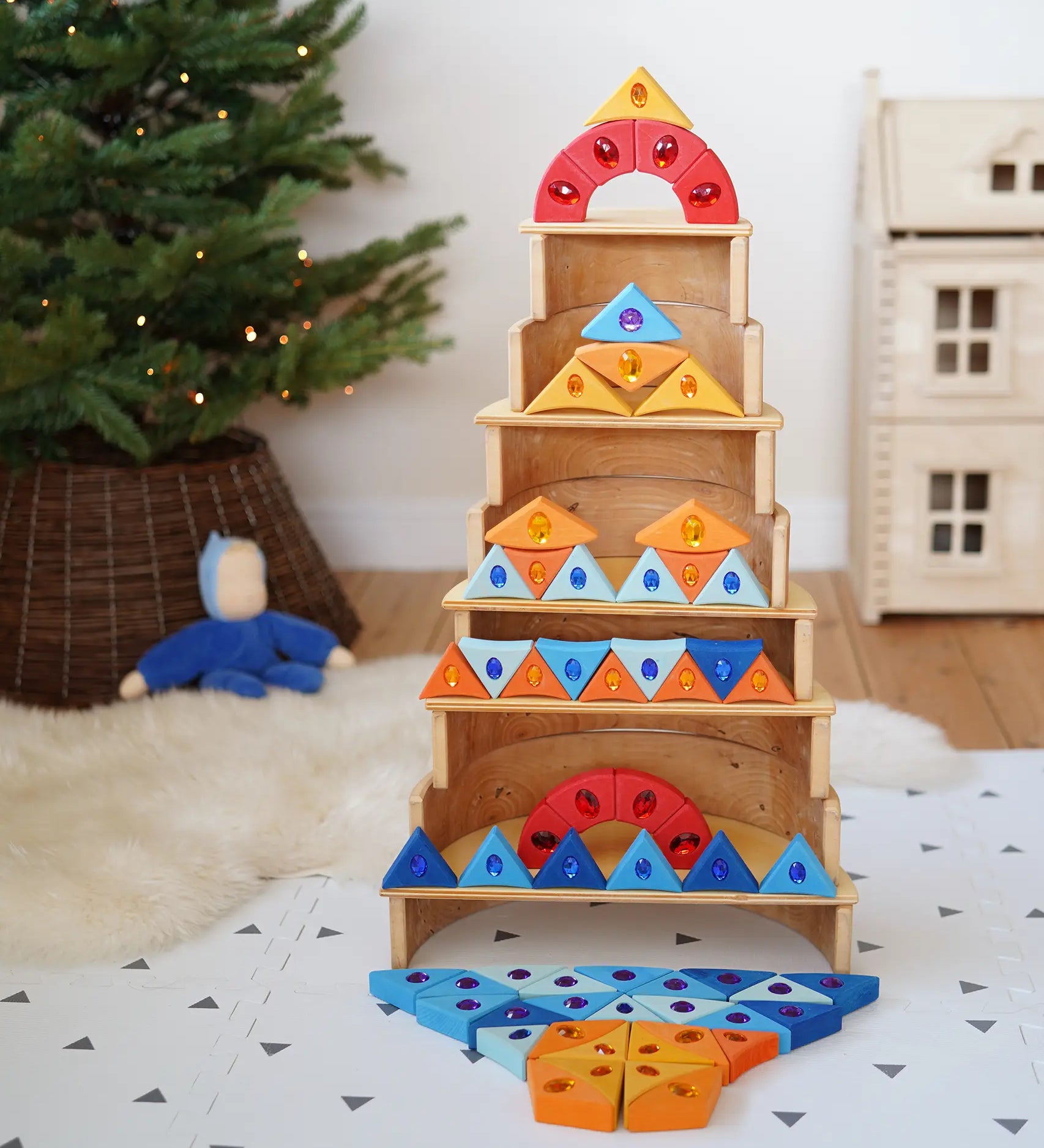 A tower stack made from wooden blocks from the Grimms sparkling mandala set and natural wooden arch pieces