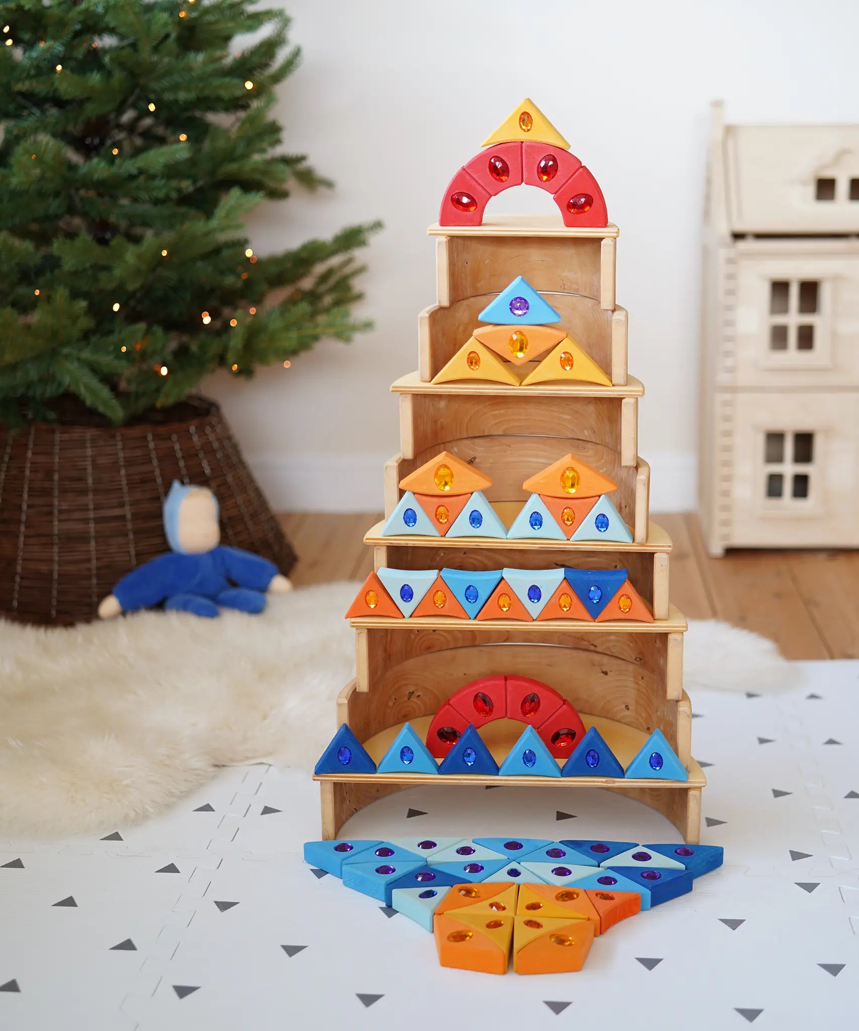 A tower stack made from wooden blocks from the Grimms sparkling mandala set and natural wooden arch pieces