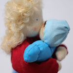 Grimm's Blonde Woman Doll is holding a small Grimm's doll to its chest, showing how the dolls can interact with each other and how they can be played with