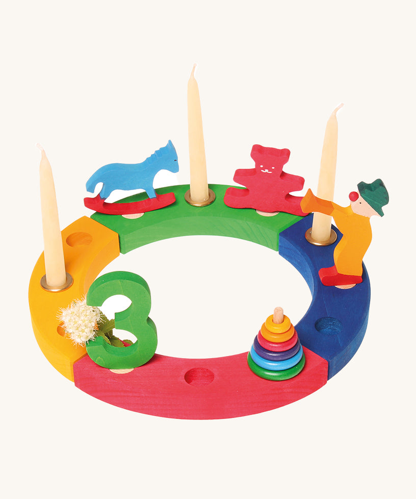 The Grimm's 12-Hole Coloured Wooden Ring with Grimm's decorative figures and candles, celebrating a third birthday