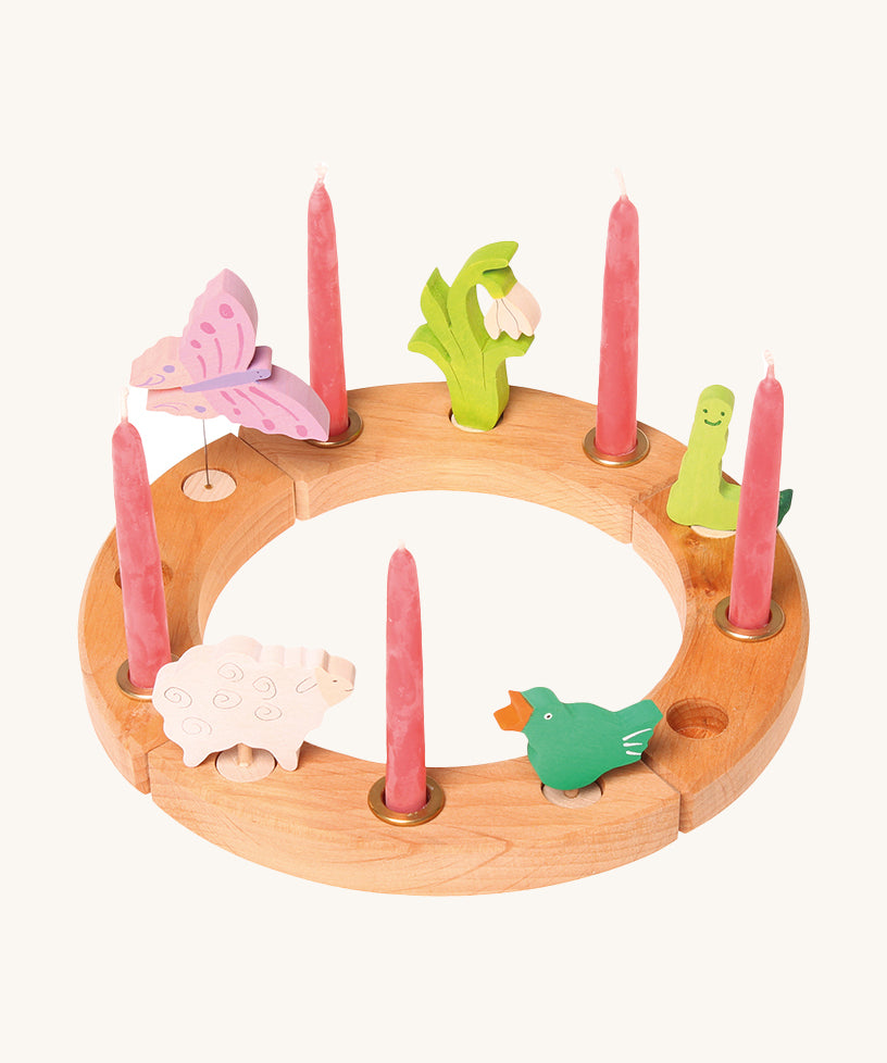 Grimm's 12-Hole Natural Wooden Celebration Ring with pink candles and springtime decorative figures, on a cream background