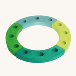 Grimm's Green-Turquoise Celebration Ring on a cream background