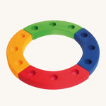 Grimm's 12-Hole Coloured Wooden Ring is made up from 4 sections of wood, yellow, red, green and blue, with 3 holes to add Grimm's decorative figures and candles inside. The image is on a cream background