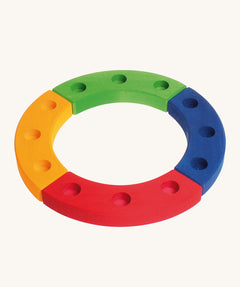Grimm's 12-Hole Coloured Wooden Ring is made up from 4 sections of wood, yellow, red, green and blue, with 3 holes to add Grimm's decorative figures and candles inside. The image is on a cream background