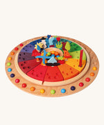 Grimm's Wooden Annual Celebration Ring with Grimm's decorative figures, marbles and a candle ready for a celebration. The image is on a cream background
