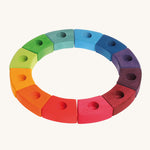 Grimm's 12-Piece Rainbow Birthday Celebration Ring on a cream background. This celebration ring has 12 individual wooden pieces each with a hole in the middle to put Grimm's decorative figures or candles inside