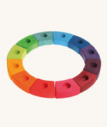 Grimm's 12-Piece Rainbow Birthday Celebration Ring on a cream background. This celebration ring has 12 individual wooden pieces each with a hole in the middle to put Grimm's decorative figures or candles inside