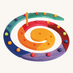 The Grimm's Coloured Wooden Spiral with marbles in each hole and an orange candle