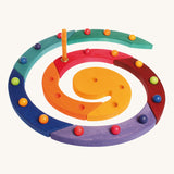 The Grimm's Coloured Wooden Spiral with marbles in each hole and an orange candle
