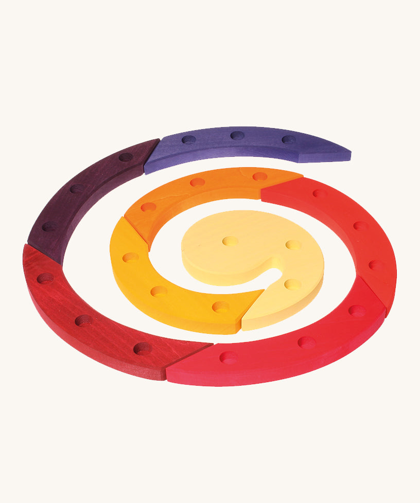 Grimm's Red Celebration Spiral is made from 8 sections of wood, each with 3 holes in for decorative figures and candles, and they make a beautiful spiral. The image is on a cream background