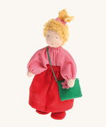 Grimm's Waldorf Blonde Girl Doll wearing a pink top, a red skirt and carrying a green felt bag with a pink flower, on a cream background