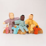 A collection of Grimm's Waldorf handmade Dolls sitting on Grimm's Natural Rainbows