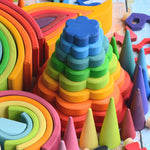 The Grimm's Stacking Flowers Tower is nestled among other Grimm's wooden toys, creating a beautiful rainbow coloured display