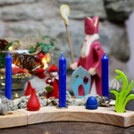 A lovely winter celebration display, made with a Grimm's Wooden Celebration ring. There are blue candles in brass holders, and colourful loose parts 